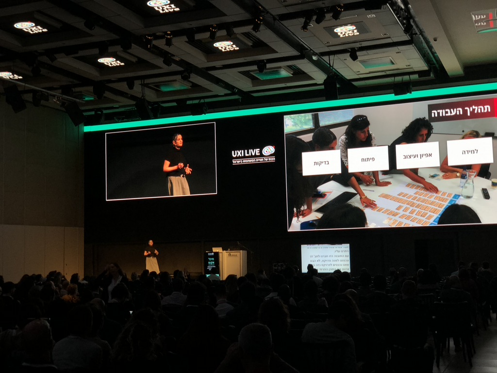 Michal Accos presenting the Portal project at UXI Live — stage screen shows work process stages and card-sorting research